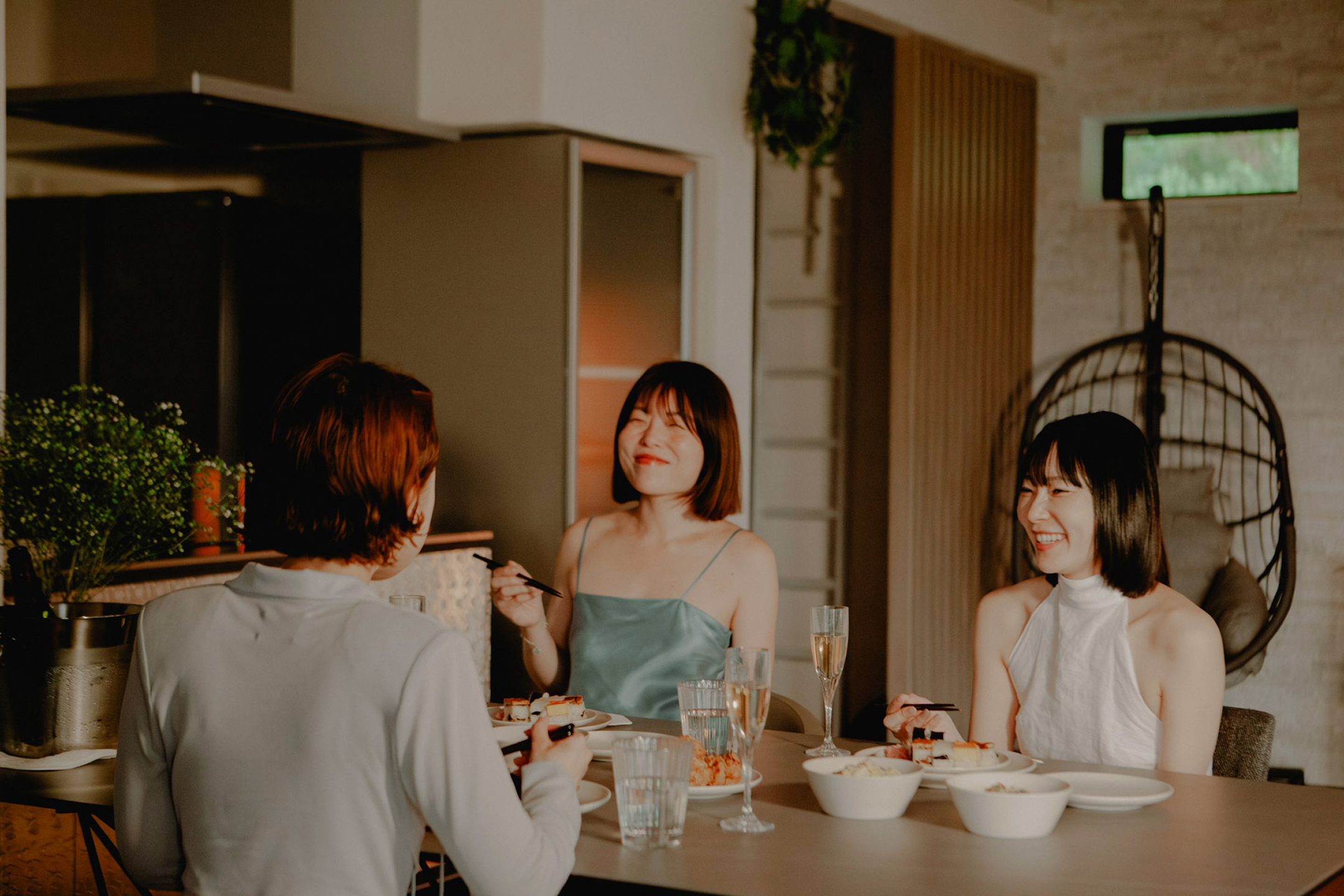 3人の女性がダイニングテーブルを囲んで大阪の郷土料理を楽しむ様子