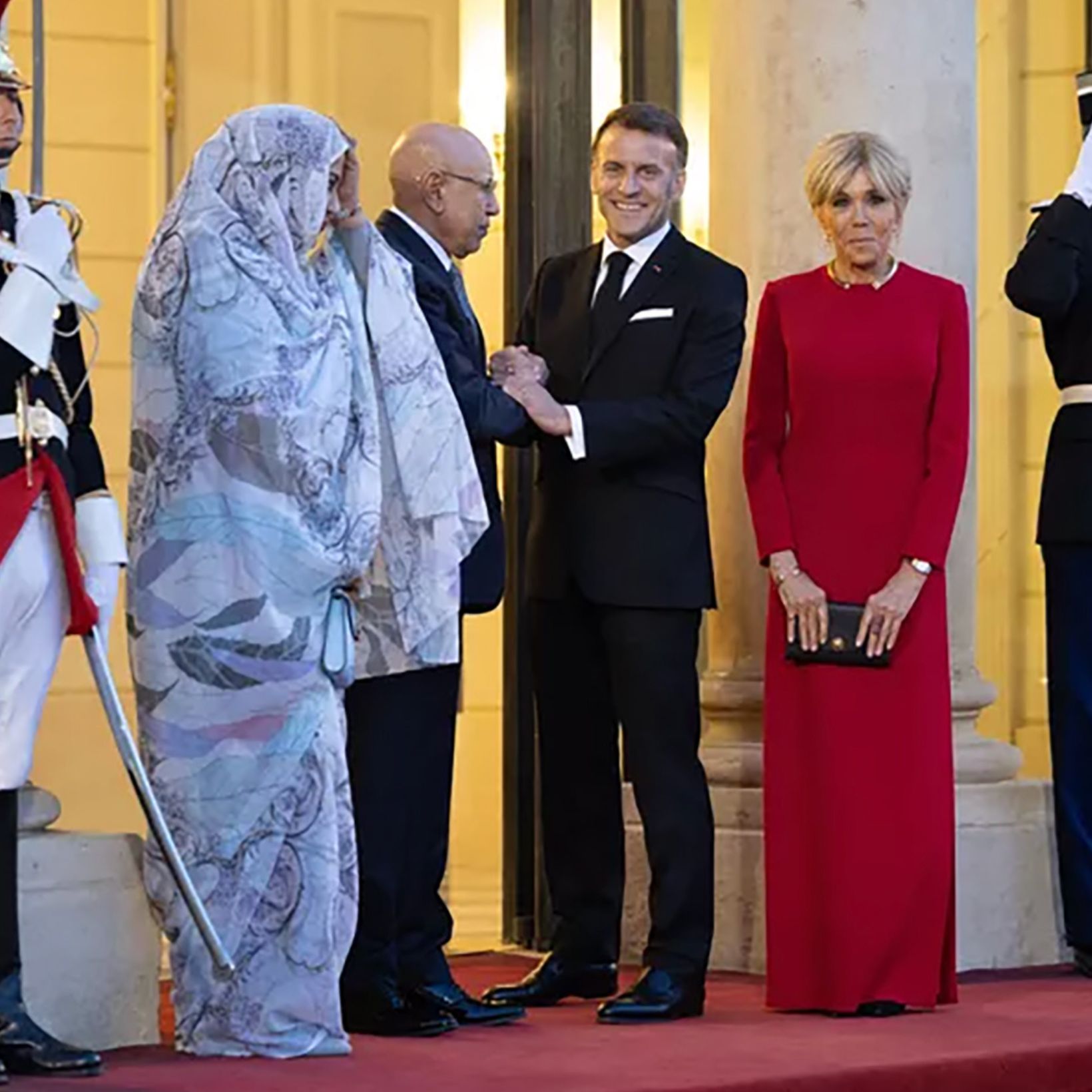 ブリジット・マクロン夫人、エリゼ宮殿で行われたモーリタニア大統領夫妻を迎えた晩餐会に、赤いドレスとブロンドのシニヨンヘアで出席。