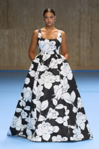 Fashion model on a runway wearing a sleeveless black and white floral ball gown with a full skirt.