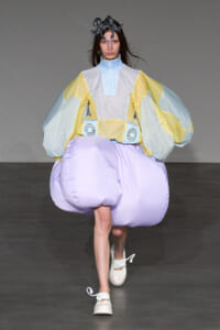 Model walking the runway in a pastel inflatable couture with oversized puff sleeves and a lavender bubble skirt, silver headpiece. (Runway fashion)