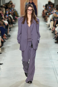 Model walks the runway in a loose lavender suit with an oversized blazer and matching wide-leg pants (fashion show).
