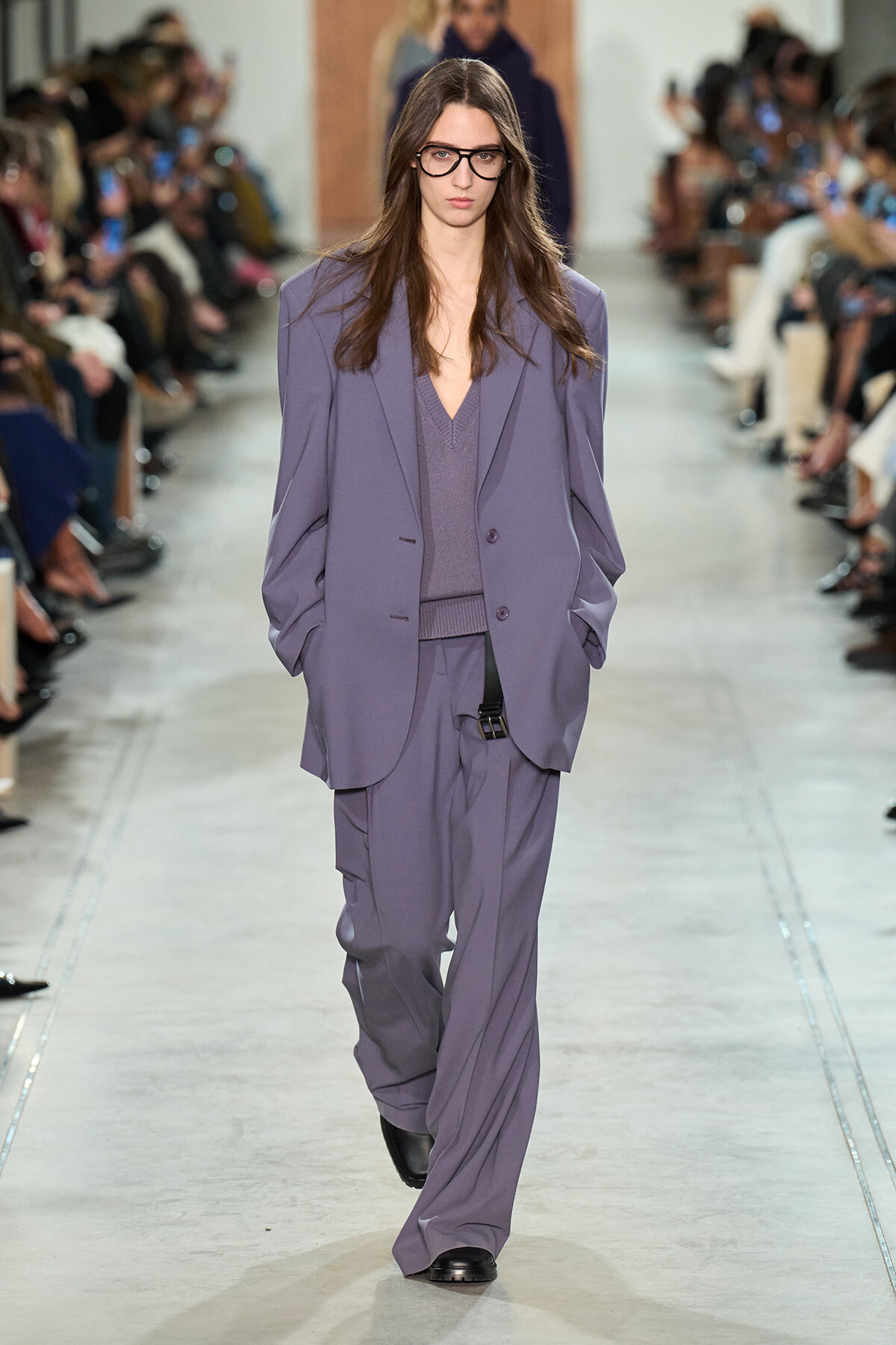 Model walks the runway in a loose lavender suit with an oversized blazer and matching wide-leg pants (fashion show).
