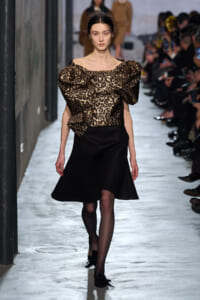 Model walks the runway in a leopard-print puff-sleeve blouse and a black A-line skirt.