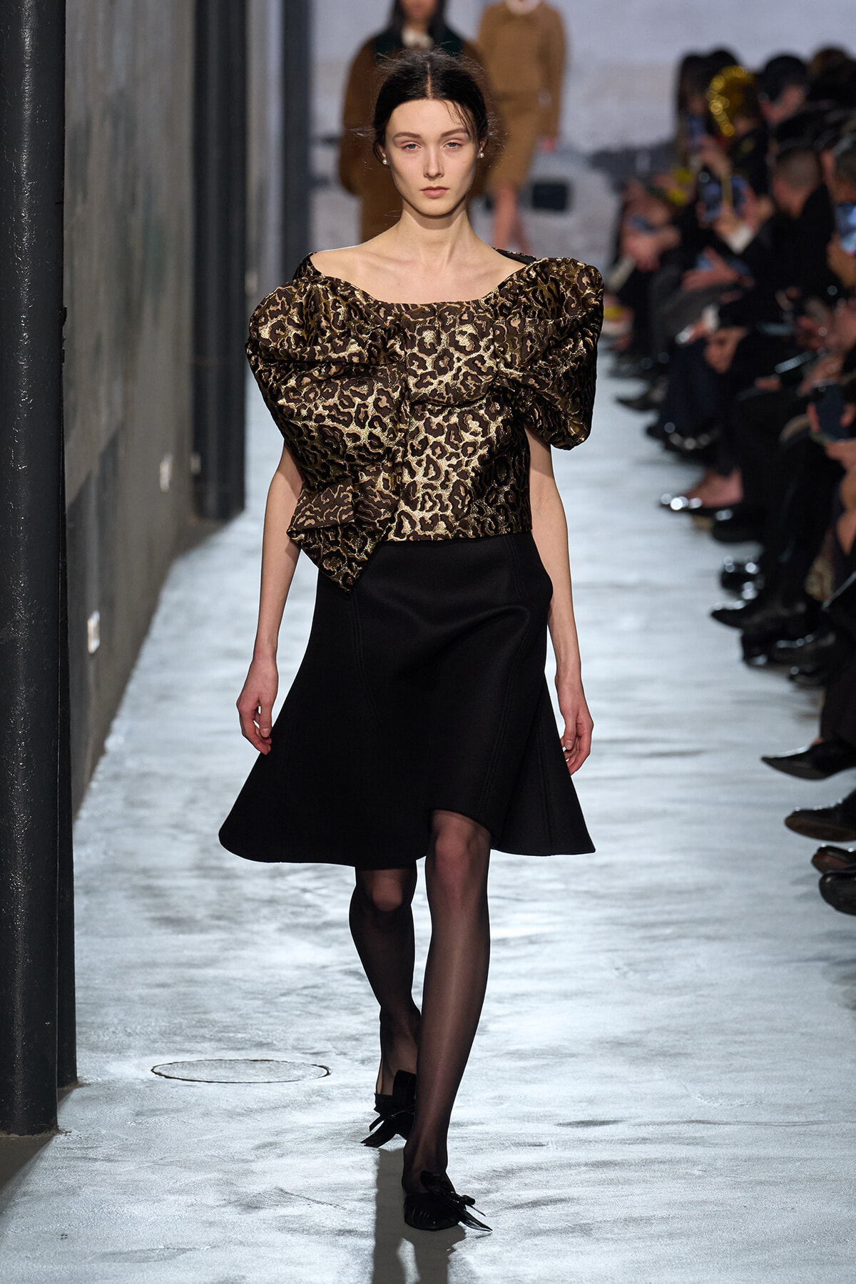 Model walks the runway in a leopard-print puff-sleeve blouse and a black A-line skirt.