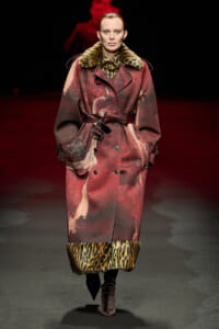 Runway model in a long burgundy coat with leopard fur trim at collar and cuffs, belted at the waist.