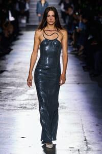 Model walks the runway in a navy sequined halter dress with a sculptural neck accessory.