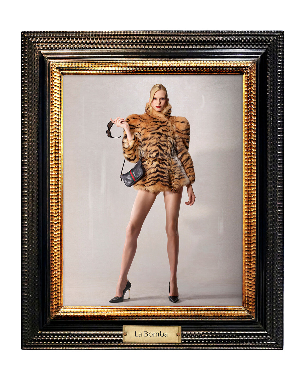 Fashion photo of a model in a tiger-print fur coat, black heels, and a small crossbody bag, holding sunglasses, inside an ornate frame labeled La Bomba.