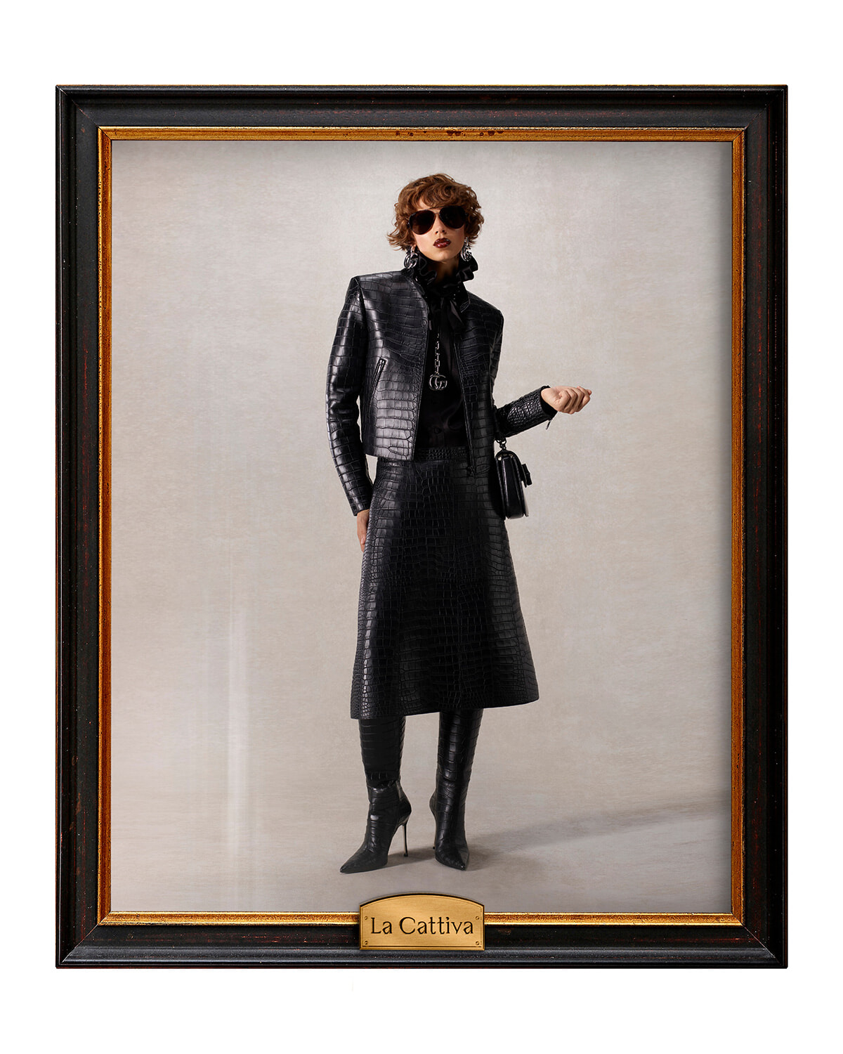 Framed fashion portrait of a woman in a black crocodile-skin coat and skirt, wearing sunglasses and holding a small black bag.