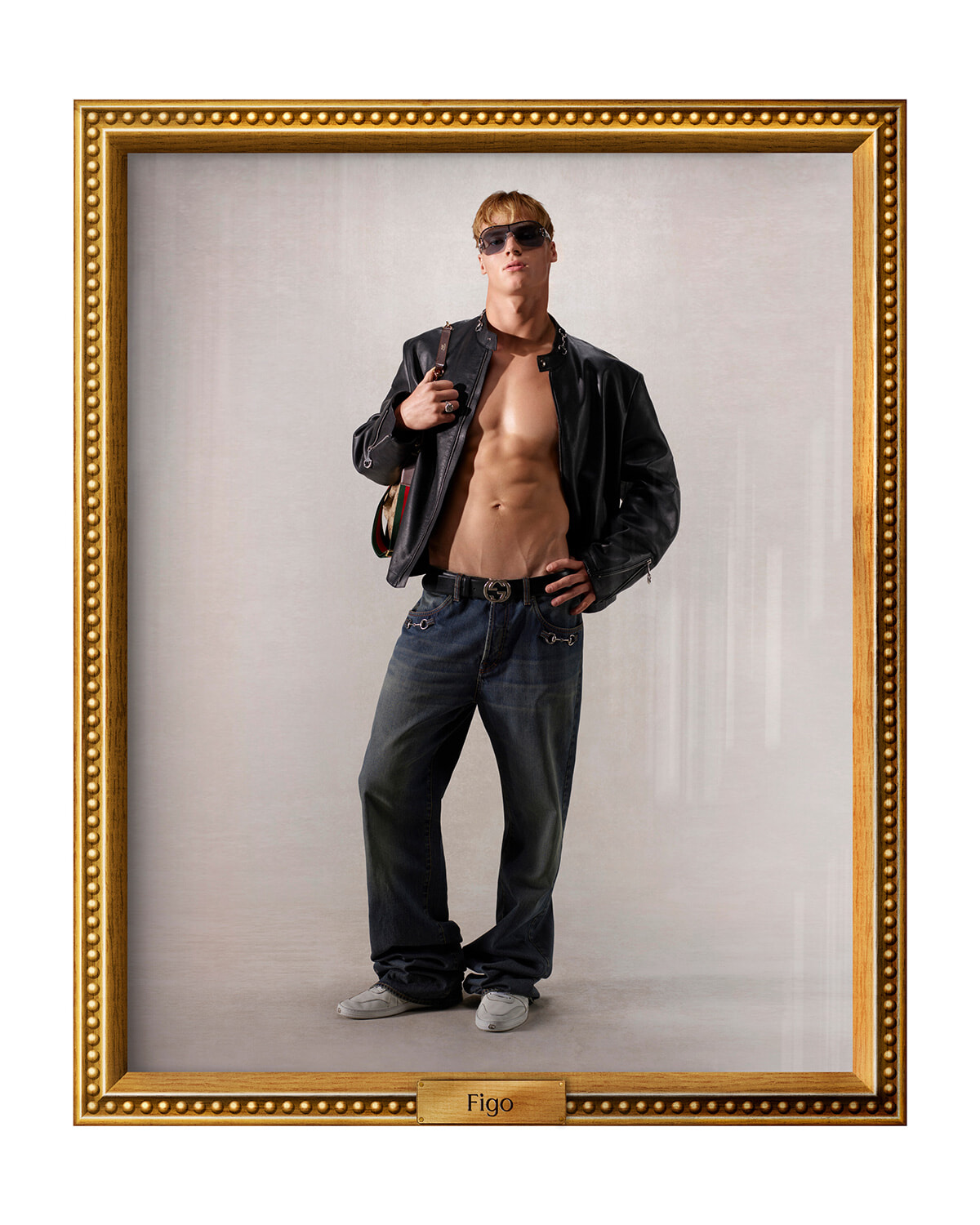 Framed portrait of a muscular man in a black leather jacket, jeans, and sunglasses, posing with one hand on his hip inside a gold ornate frame labeled 'Figo'.