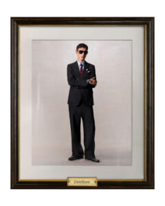 Portrait of a man in a black suit and sunglasses, arms crossed, framed with a bottom plaque reading Direttore.