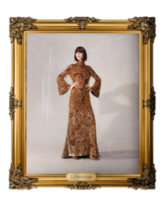 Portrait of a woman in a full-length gold-sequin gown inside an ornate gold frame labeled La Mecenate.