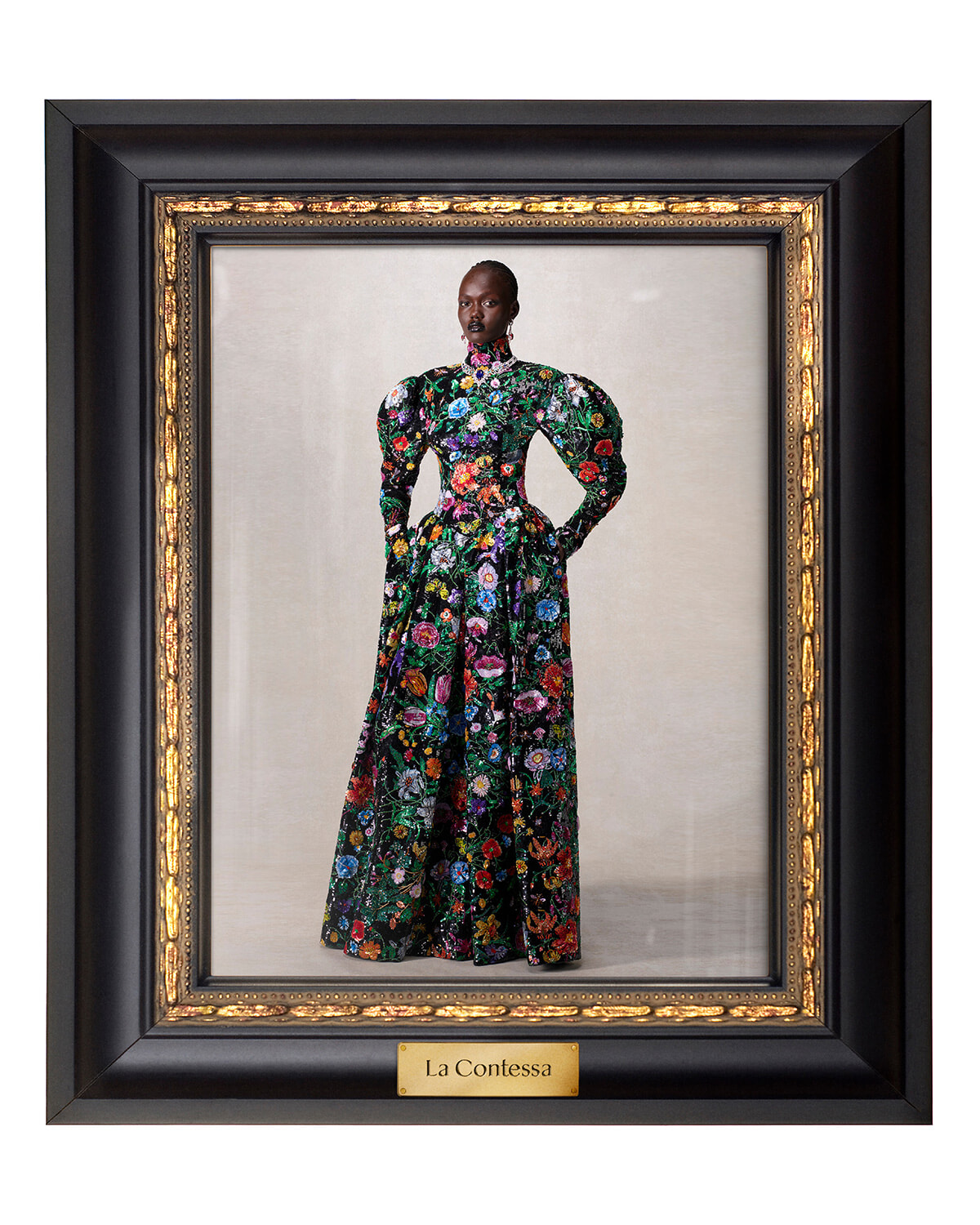 Portrait of a woman in a long, vibrant floral gown, standing with hands on hips inside a black and gold ornate frame, titled 'La Contessa'