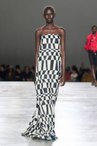 Model walks the runway in a strapless, floor-length black-and-white geometric checkerboard dress on the catwalk.
