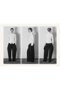 Triptych of a model wearing a textured white blazer and wide black trousers, shown from front, side, and back.