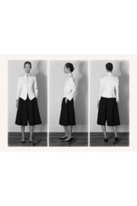 Three-panel grayscale photo of a woman in a white tailored blazer and black culottes, shown in front, side, and back views.