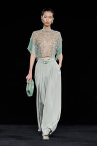 Runway look: mint beaded lace top with fringe sleeves paired with pale gray wide-leg trousers and a mint clutch.