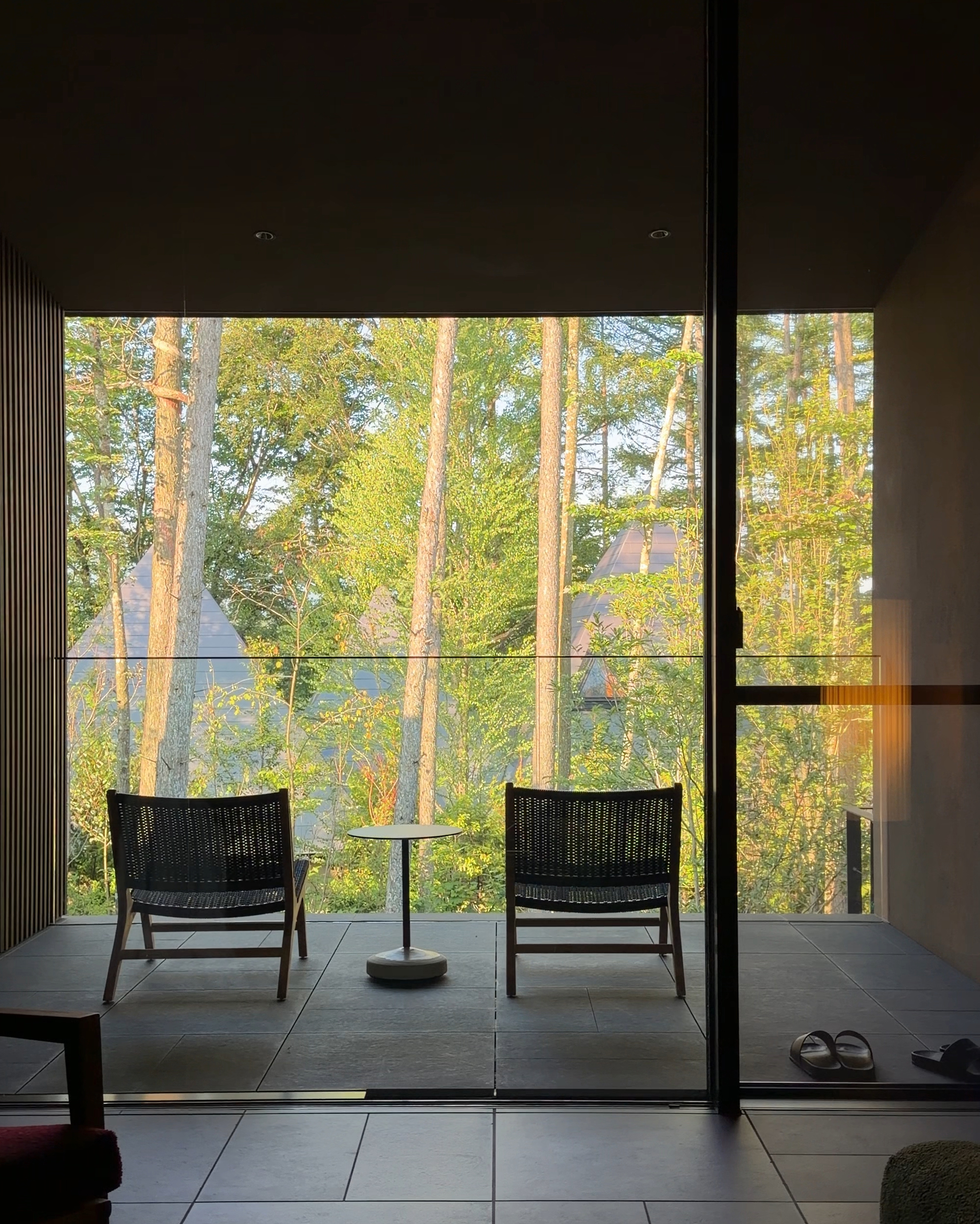 2026-07-21-karuizawa-solo-trip-essence-karuizawa | madameFIGARO.jp(フィガロジャポン) 壁一面の大きな窓から自然光が差し込むエッセンス軽井沢のスイートルーム