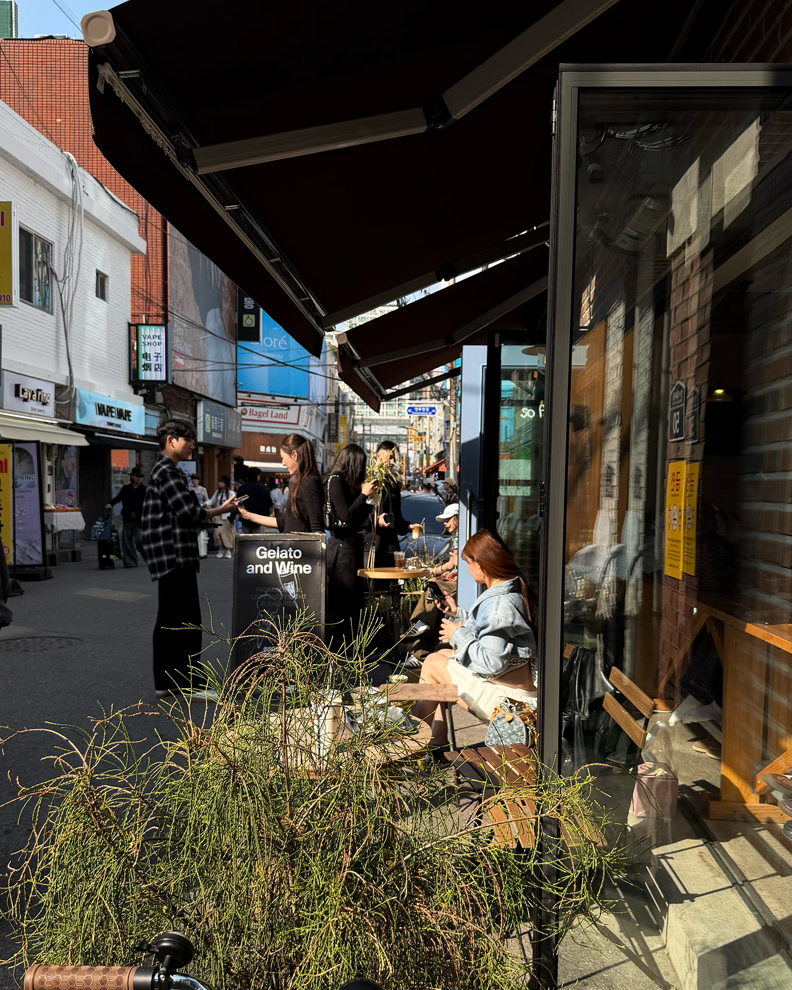 so farの店先テラス。日除けの下、屋外の席で過ごす人々