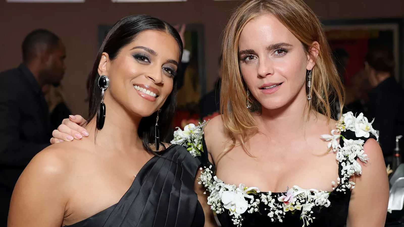 261008-emma-watson-lucas-museum-1600 | madameFIGARO.jp(フィガロジャポン) 白い蘭やカスミソウの生花をネックラインにあしらった黒のドレス姿のエマ・ワトソンと、ワンショルダーの黒いドレスを着たリリー・シン。ルーカス・ミュージアム・オブ・ナラティブ・アートの開館式にて。