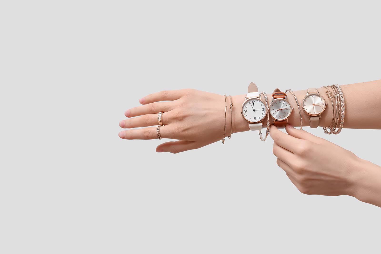FemaleHandsWithGoldenWristwatchesAndBraceletsOnWhiteBackground | madameFIGARO.jp(フィガロジャポン)