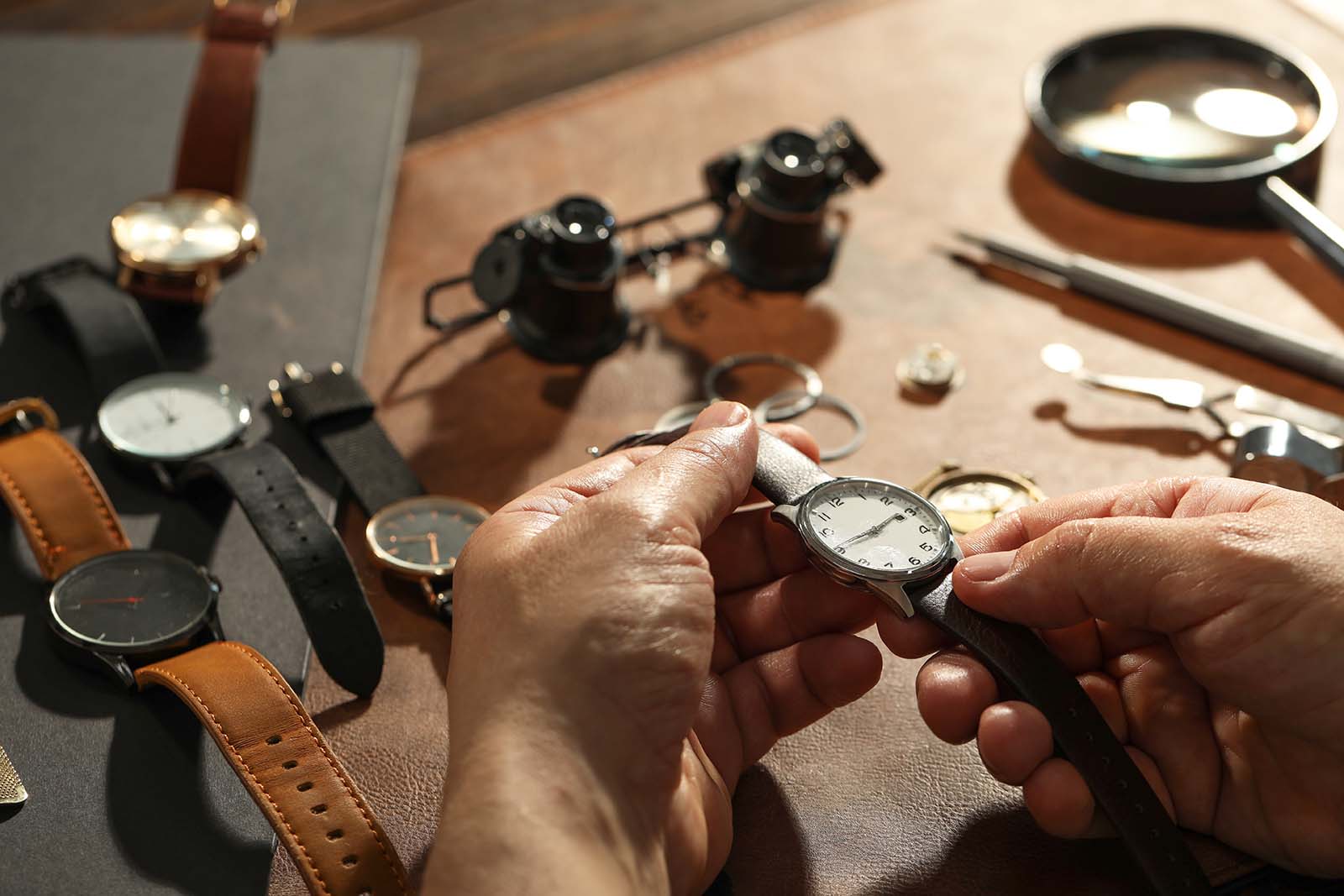 ClockMechanismManWithVintageWristWatchAtTableCloseup | madameFIGARO.jp(フィガロジャポン)