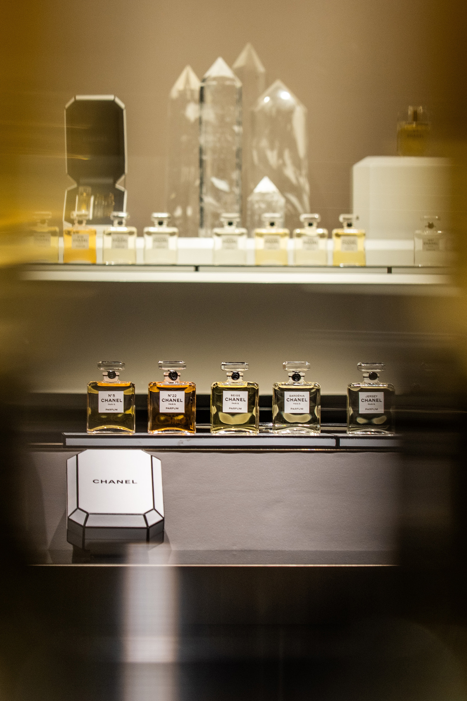 261020-chanel-grand-parfumeur-06 | madameFIGARO.jp(フィガロジャポン) 棚に並ぶレ ゼクストレ ドゥ シャネルのボトルと、白いボックス
